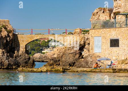 Palma, Maiorca, Spagna. 17 luglio 2022 - es Pujolar sulla spiaggia di Cala Major, un piccolo ponte verso una piccola isola vicino alla costa. Sullo sfondo la città di Foto Stock