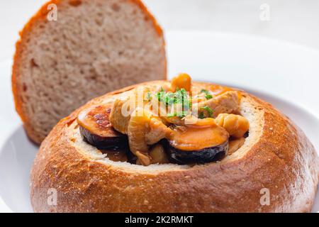 stufato con carne di maiale, ceci e sausge in pane Foto Stock