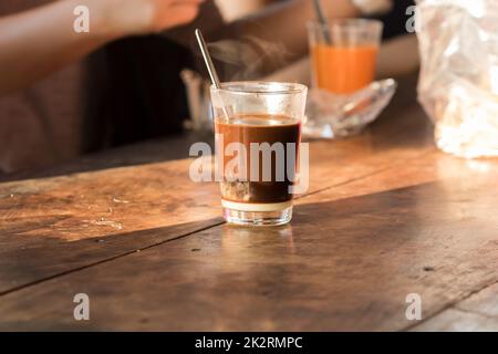 Caffè caldo in un bicchiere, mettere sul tavolo Foto Stock