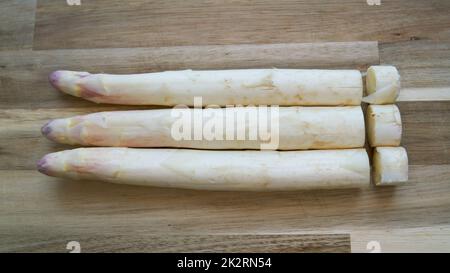 asparagi freschi con estremità tagliate su un tavolo in cucina Foto Stock