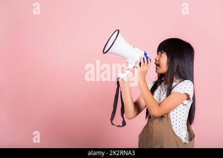 Ragazzino asiatico di 10 anni urla dal megafono Foto Stock