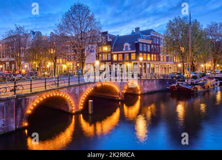 Amterdam canal, il ponte e le case medievali di sera Foto Stock