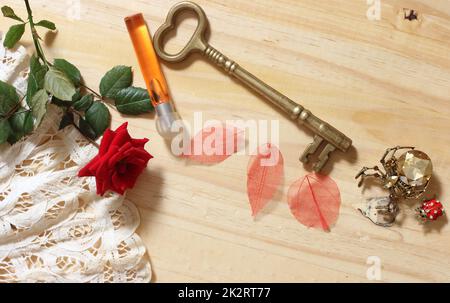 Chiave in ottone vintage con ventilatore in pizzo e rosa rossa Foto Stock