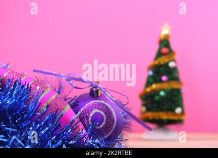 Ornamenti di Natale e albero di Natale su sfondo rosa, basso DOF Foto Stock