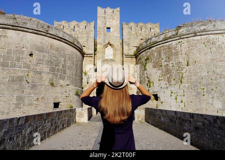 Turismo in Grecia. Vista posteriore della ragazza turistica che visita le antiche fortificazioni di Rodi, Grecia. Sito patrimonio dell'umanità dell'UNESCO. Foto Stock