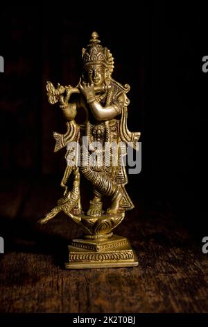 Krishna statua su sfondo di legno Foto Stock