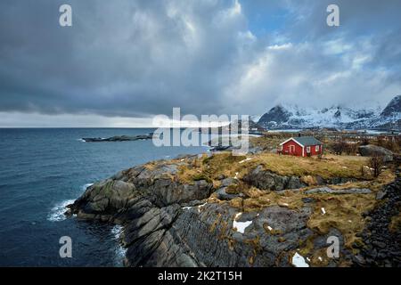 Clif con tradizionale rosso rorbu casa sulle Isole Lofoten in Norvegia Foto Stock