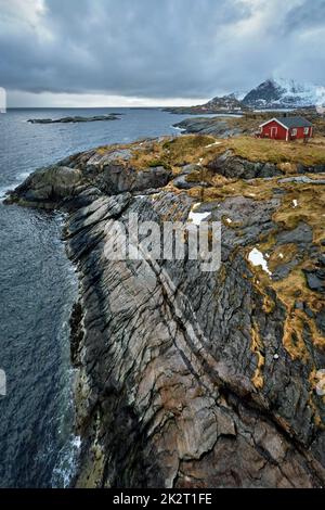 Clif con tradizionale rosso rorbu casa sulle Isole Lofoten in Norvegia Foto Stock