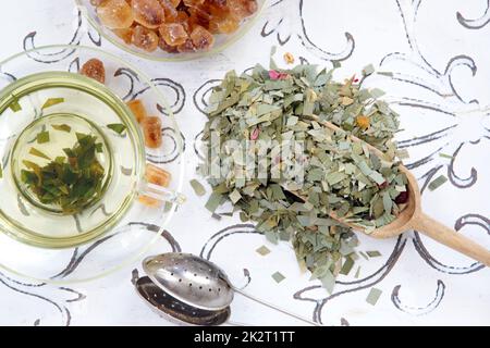 Infusione di erbe di tè di citronella in una pala di tazza di vetro e filtro del tè Foto Stock