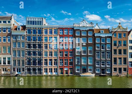Case e barca sul canale di Amsterdam Damrak con la riflessione. Ams Foto Stock