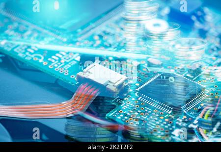 Scheda elettronica e pila di monete. Scheda madre del computer. Industria elettronica di affari. Scheda a circuiti integrati del computer. Memoria dell'hardware di informazioni digitali. Tecnologia di ingegneria elettronica. Foto Stock