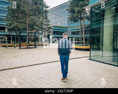 Un uomo va a lavorare in un quartiere moderno Foto Stock