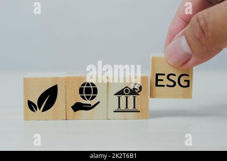 Mettere a mano cubi di legno con ESG Environmental Social Governance simbolo sul tavolo copia space.Business concetti. Foto Stock