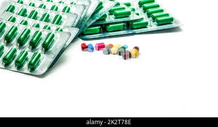 Pillola di capsula di antibiotico verde in blister e pillola di capsula multicolore su sfondo bianco. Concetto di resistenza agli antibiotici e farmaci da prescrizione. Prodotti farmaceutici. Industria farmaceutica. Foto Stock