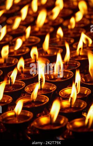 Candele accese nel tempio buddista. Dharamsala, Himachal Pradesh Foto Stock