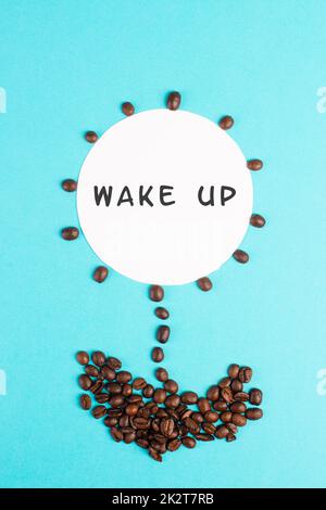 Fiore fatto con i chicchi di caffè, le parole svegliarsi sono in piedi sul fiore, buon mattino, avendo un espresso per la prima colazione, bevanda calda Foto Stock