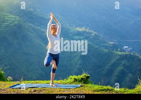 Donna fare yoga asana tree pongono all'aperto Foto Stock