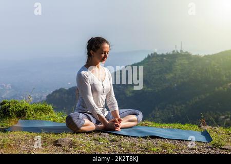 Donna pratica Yoga asana Baddha Konasana all'aperto Foto Stock