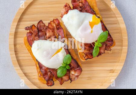 Sandwich con uova in camicia e pancetta Foto Stock