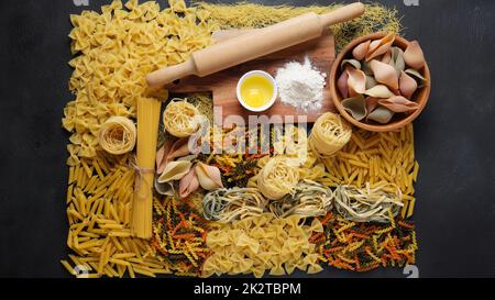 Assortimento di pasta cruda. Diversi tipi di maccheroni, tagliatelle, farfalle, spaghetti, penne rigate . Colorato, rosso, verde, giallo, noodle. Foto Stock