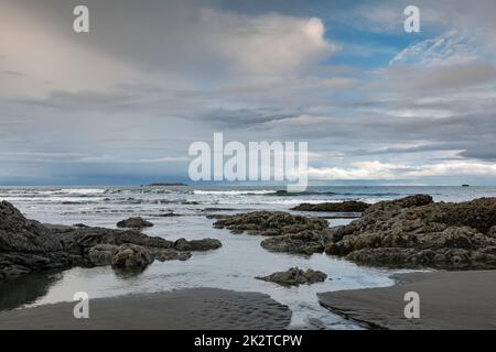 WA22067-00...WASHINGTON - rocce marciacee esposte su una spiaggia sabbiosa Ruby Beach nel Parco Nazionale Olimpico, con il Faro di Destruction Island in lontananza. Foto Stock