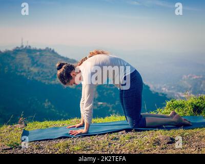 Montare sportivo donna le pratiche yoga asana Marjariasana all'aperto Foto Stock