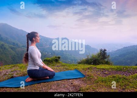 Donna fare Yoga asana Virasana eroe pongono Foto Stock