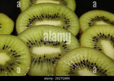 Primo piano di fette di kiwi su sfondo nero. Fondo di frutta. Foto Stock