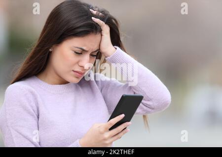 Teen preoccupato di controllare le cattive notizie sullo smartphone Foto Stock