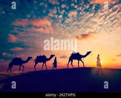 Due camelisti con cammelli in dune Foto Stock