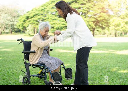 Assistenza e cura degli operatori asiatici anziani anziani o anziani anziana donna paziente seduta e felice su sedia a rotelle nel parco, sano forte concetto medico. Foto Stock