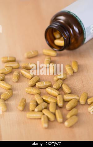 Pillole di supplemento di Vitamina versato da una bottiglia Foto Stock