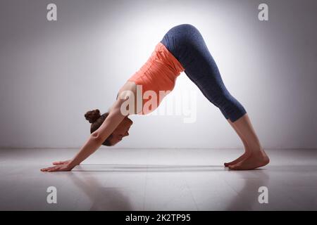 Bella sportiva montare yogi girl le pratiche yoga asana adhomukha sv Foto Stock