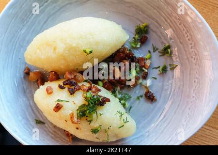 Piatto nazionale della Lituania Cepeline o zeppeline - gnocchi di patate a base di patate grattugiate e ghiacciate e farcite con carne macinata, formaggio di cagliata secco o funghi Foto Stock