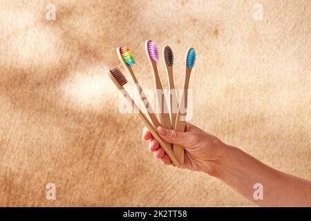 Crop donna con la collezione di colorati spazzolini da denti di bambù Foto Stock