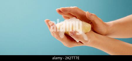 Crop donna applicare schiuma con una spugna sulle mani Foto Stock