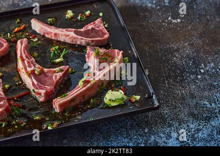 Costolette di agnello crudo sul vassoio Foto Stock