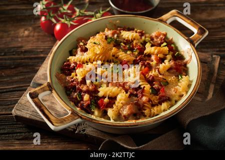 Piatto da forno con deliziosa pasta su asse di legno Foto Stock