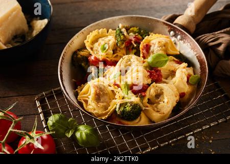 Deliziosi tortelloni con foglie di spinaci su stativo in metallo Foto Stock