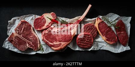 Bistecche di carne assortite e polpettine di hamburger su carta sgualcita Foto Stock