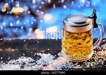 Bicchiere di birra sul tavolo con neve Foto Stock