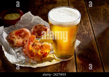 Pinta fredda di lager in un bicchiere con gamberi alla griglia Foto Stock