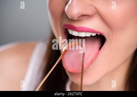 Pulizia donna sua lingua con il detergente Foto Stock