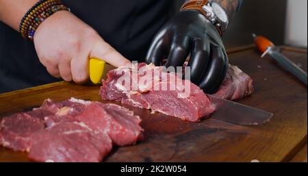 Taglio di pezzi di carne di manzo cruda fresca. Carne fresca succosa. Foto Stock