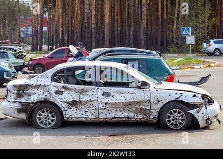 Un'auto distrutta da un razzo che esplose nelle vicinanze. Cimitero automobilistico Irpensky. Conseguenze dell'invasione dell'esercito russo in Ucraina. Veicolo civile distrutto. Foto Stock