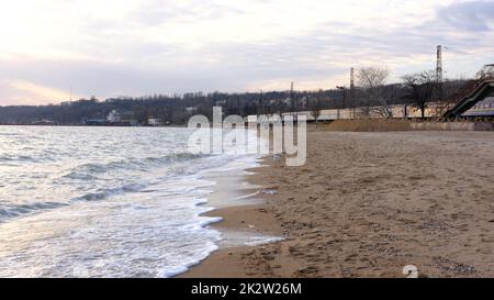 Azov mare onde schiuma leggera brezza, spiaggia di sabbia durante il giorno in estate al sole. immagine ravvicinata del mare infuriante al tramonto della sera Foto Stock