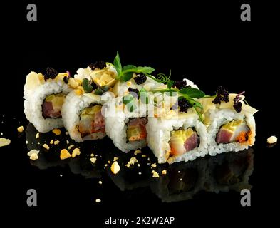 Impostare il rotolo di sushi. Cucina giapponese tradizionale. Isolato su sfondo nero Foto Stock