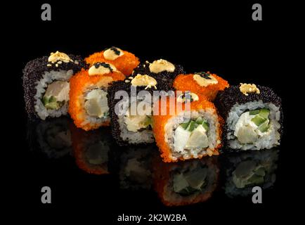 Impostare il rotolo di sushi. Cucina giapponese tradizionale. Isolato su sfondo nero Foto Stock