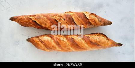 Baguette appena sfornata su sfondo chiaro. Foto Stock