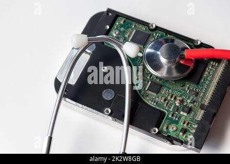 Stetoscopio rosso con unità disco rigido interna hdd contiene la cartella clinica e i dati sensibili del paziente con controllo medico hardware e riposo prima della perdita di dati in caso di guasto del sistema di archiviazione o violazione della crittografia Foto Stock